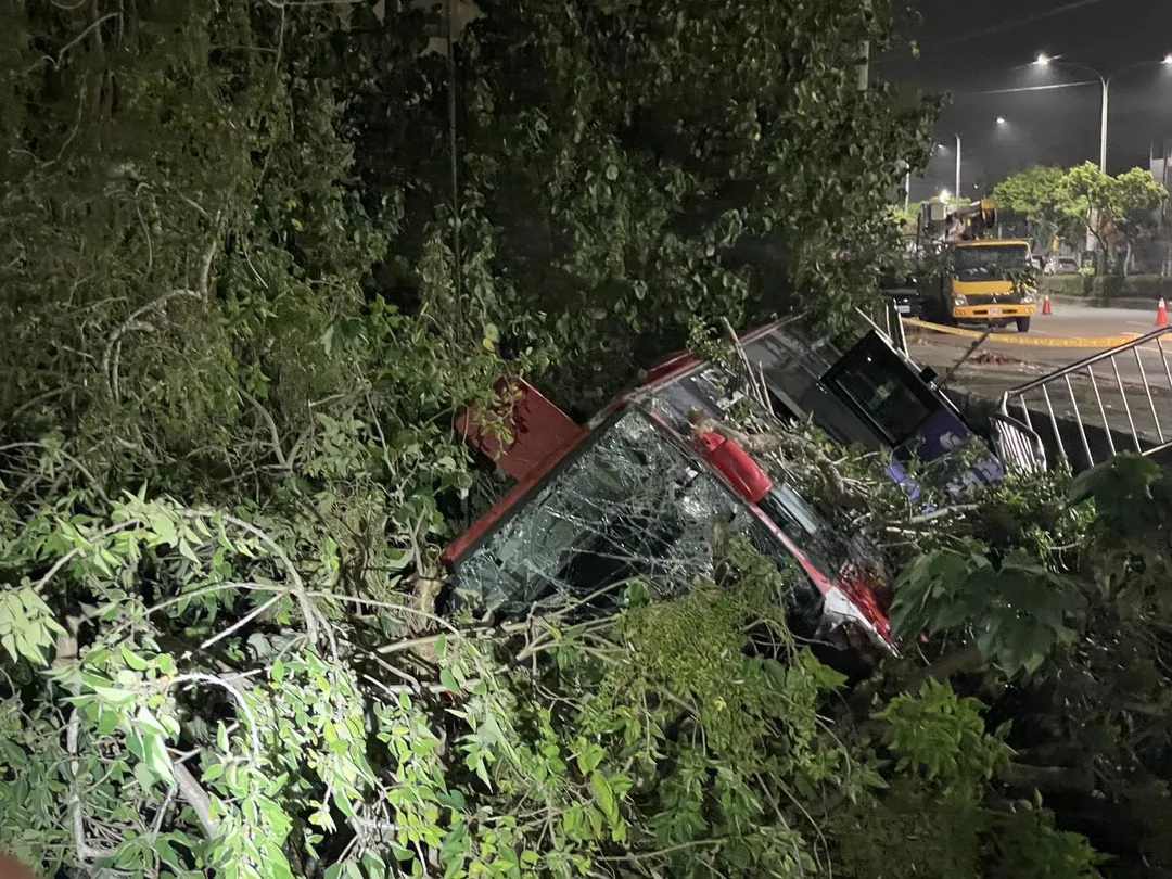 中鹿客運617路公車行經沙田路六段鷺山橋附近時失控衝破護欄，整輛車滑落邊坡側翻卡在樹林間。（圖／中天新聞）