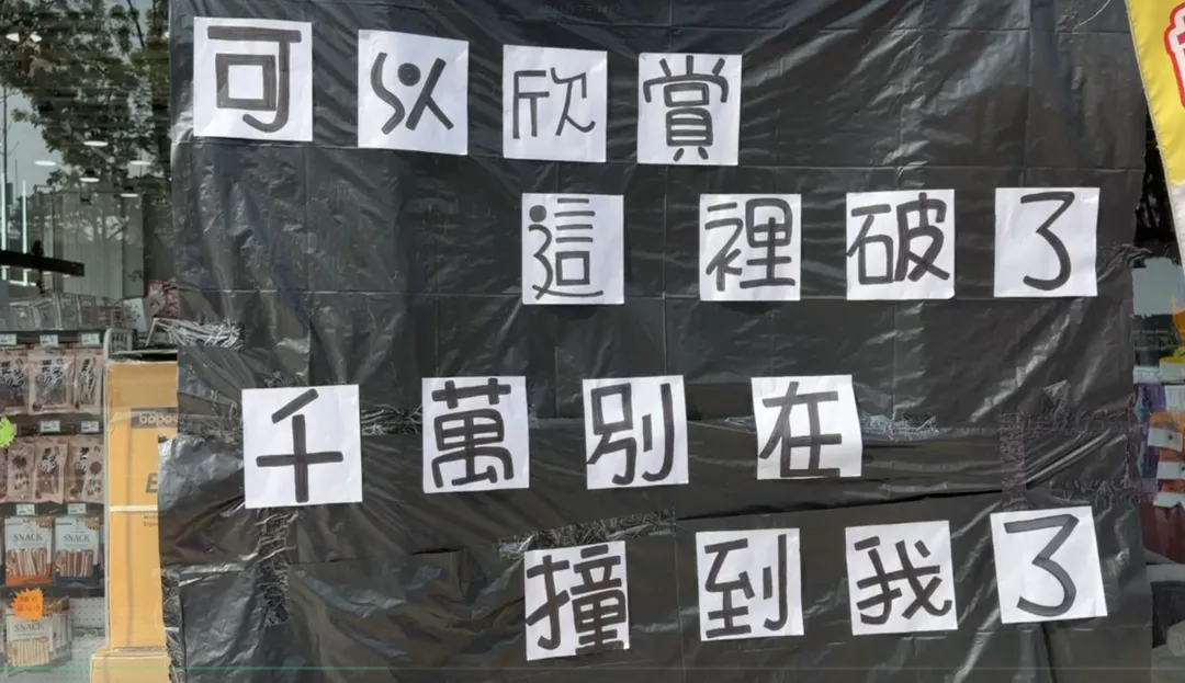 玻璃被撞碎後，店家貼上了暖心標語。（圖／中天新聞）