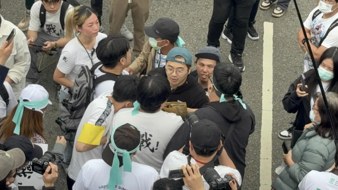 帽T男想舉標語遭包圍帶離，小草一陣怒罵。（圖/陳奕廷攝)