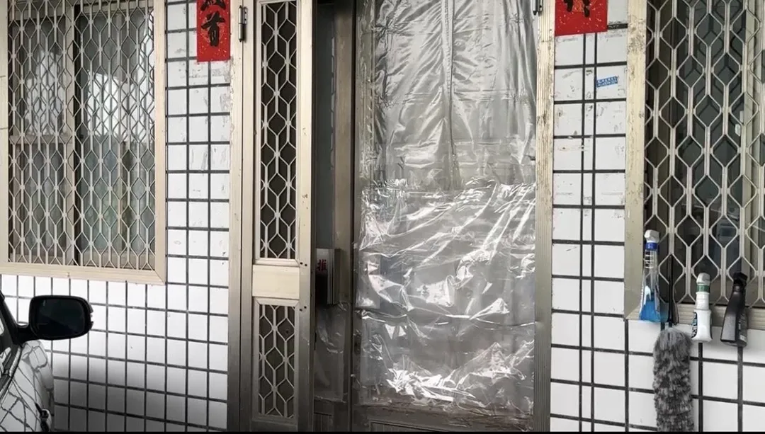 案發現場的大門破了，目前暫時用塑膠布遮住。（圖／中天新聞）