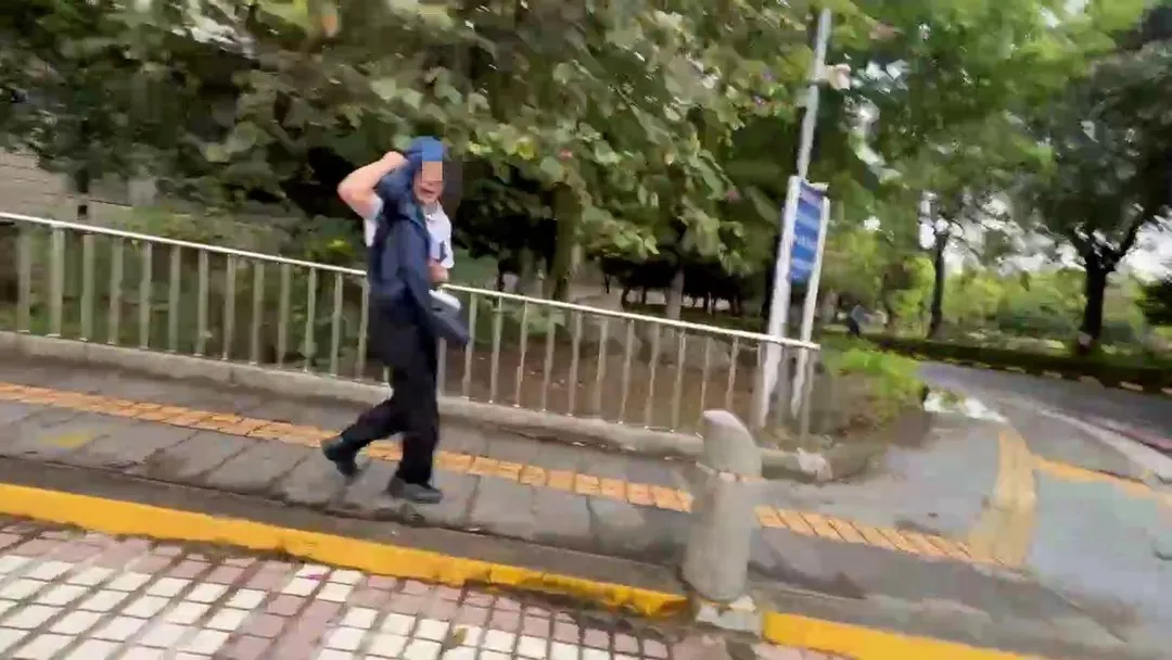 邱姓副院長一出法院在友人護駕下，用外套遮臉倉皇落跑。（圖／中天新聞）
