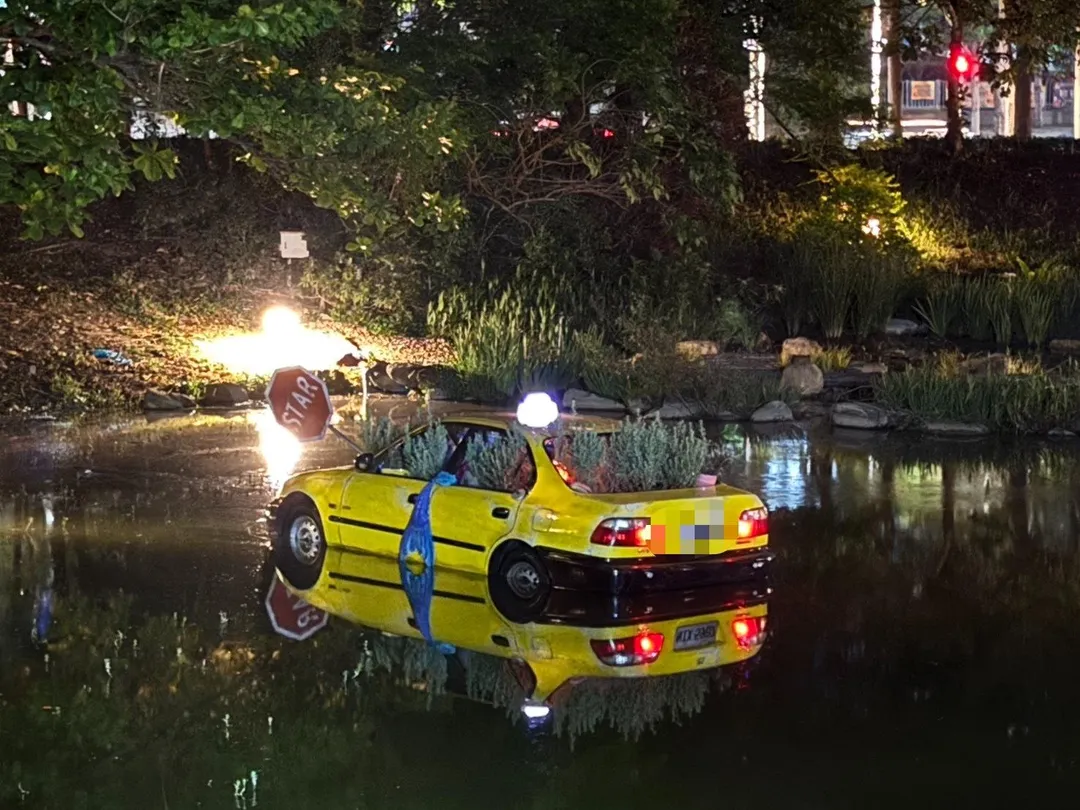 有民眾1日晚間發現高雄市立美術館園區內，有輛計程車泡在湖面上。警消到場發現是虛驚一場。（圖／警方提供）