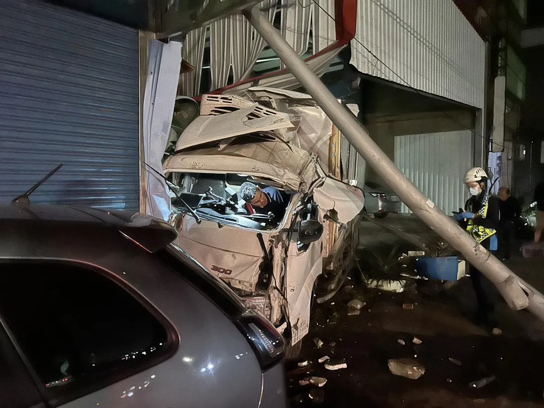 車禍造成號誌桿連根被鏟起、彎曲成C字形,貨車車頭也嚴重毀損,還波及一旁民宅。(圖/警方提供)