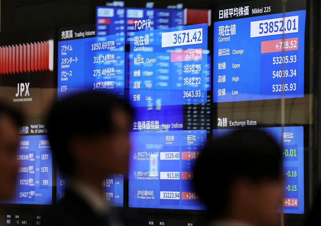 圖為東京證券交易所，訪客經過顯示當前市場資訊的螢幕。（資料照／路透社）