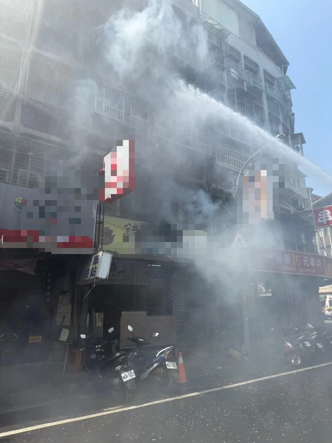 2樓冷氣室外機起火消防人員灑水灌救。(圖/翻攝畫面)