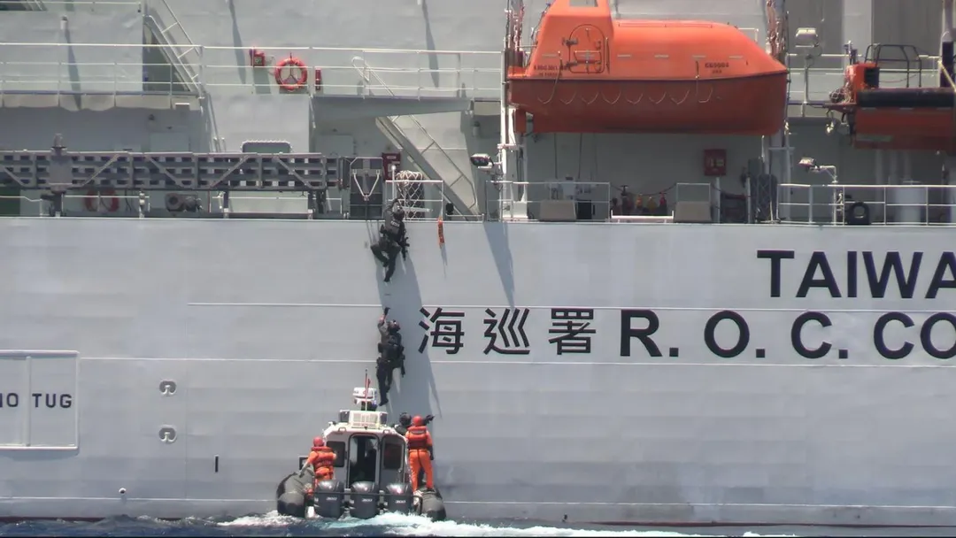 海巡特勤隊員搭乘沿岸多功能艇靠近，攀爬登上模擬可疑船隻的雲林號海巡艦。(圖/海巡署)