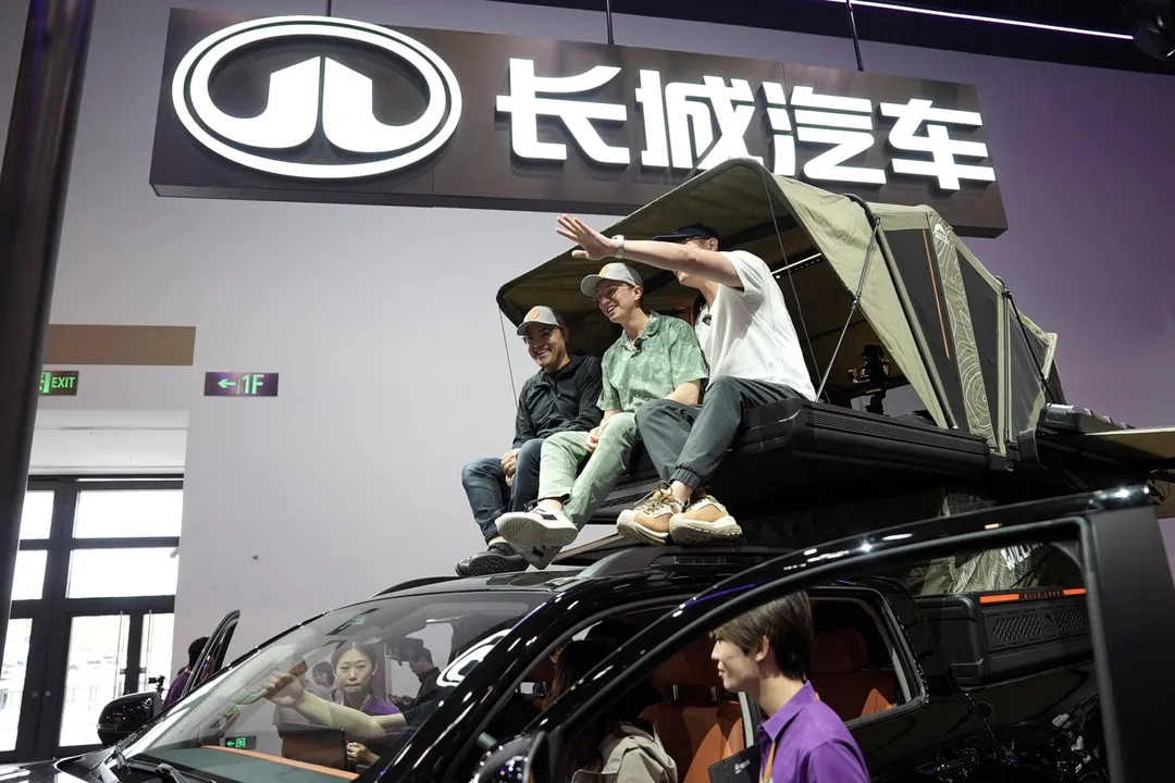 羅伯森與友人一起坐在北京車展的長城汽車Hi4-T越野車上。 （圖／路透社）