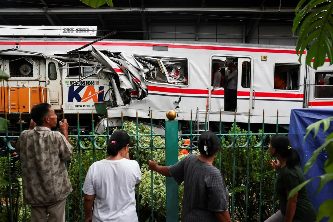 4月28日，印尼雅加達郊區的勿加西，通勤列車與長途火車發生致命相撞事故後，民眾在附近圍觀。（圖／路透社）