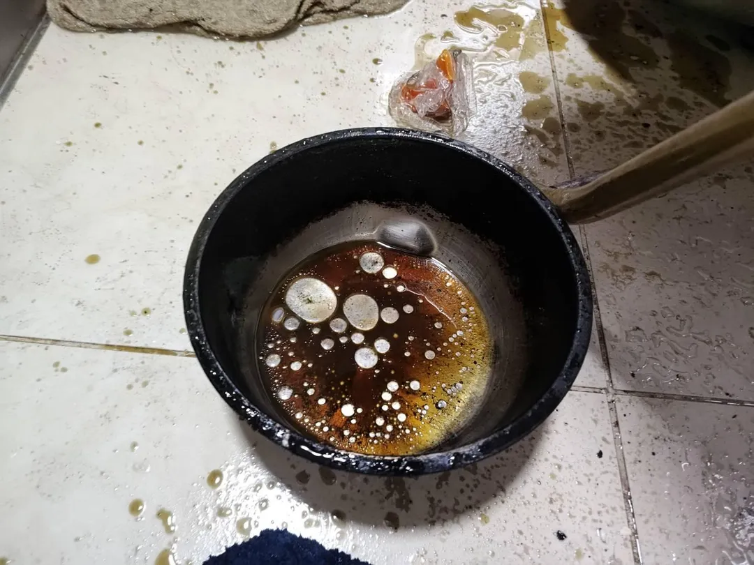 油鍋起火切勿以水滅火，水遇高溫體積膨脹1700倍，高溫水蒸氣竄出及熱油飛濺，易使火勢擴大及人員受傷。相片中油鍋內留有圓形被油包覆水，地面有飛濺之油漬痕。（圖／新竹縣政府消防局）