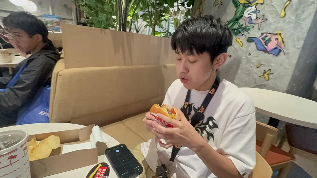 首次嚐鮮的李同學對漢堡評價保守，但仍吃得津津有味。（圖／陳奕廷攝）