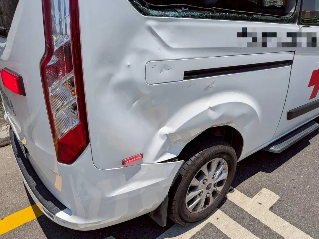 機車撞上救護車右後側，救護車右後車窗玻璃完全碎裂，車身被撞出明顯凹痕。（圖／警方提供）