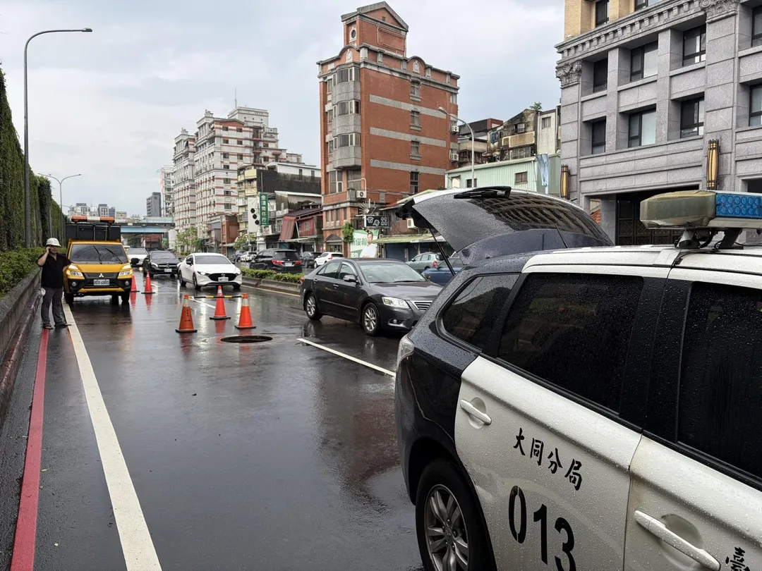 北市環河北路一段389號對面車道人孔蓋噴飛，造成路面凹洞，計3部路過車輛不慎壓到凹洞爆胎，幸無人受傷。（圖／翻攝畫面）