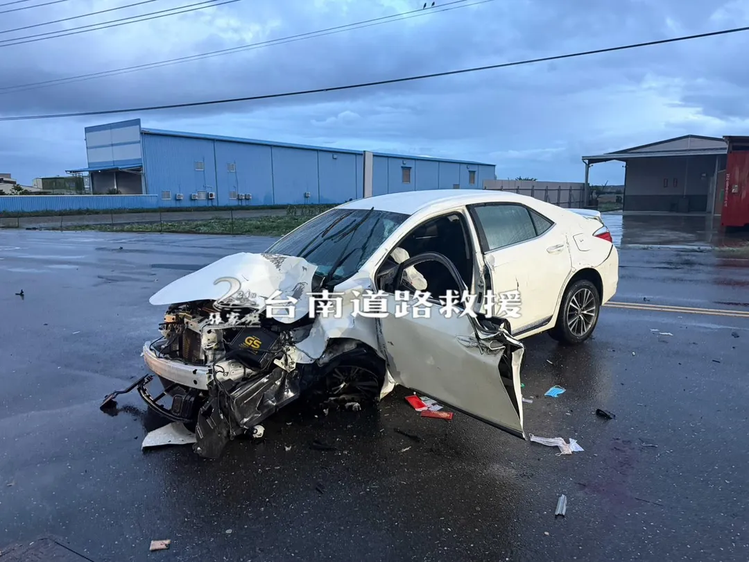 肇事轎車高速自撞路旁燈桿，車頭嚴重凹陷變形、零件散落一地，顯見撞擊力道之大。（圖／台南道路救援張家班）