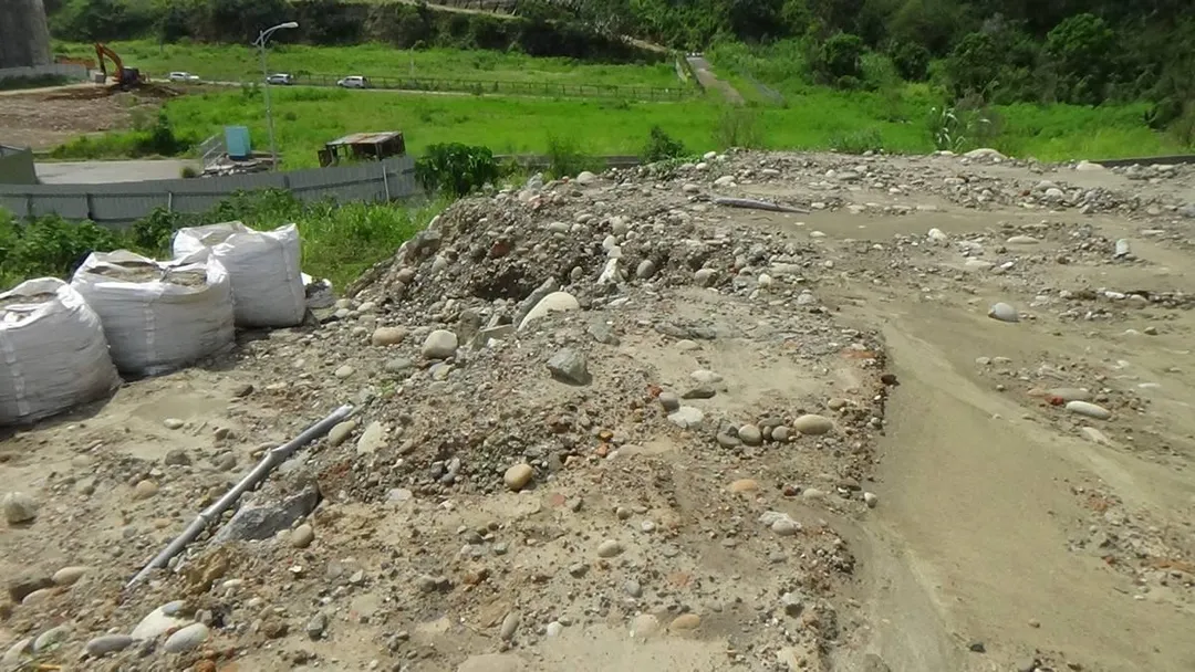 遭違法堆置的廢土中，夾雜著水管、磚角與瓦片等大量營建廢棄物。（圖／台中地檢署提供）