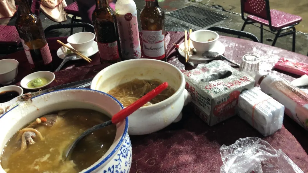 有部分熱血民眾索性直接在座位上撐起雨傘、穿上雨衣,頂著風雨繼續大口吃肉、喝湯,一邊苦笑直呼這根本是「前所未有的經驗」,大雨讓菜餚「自動加一味」,雖然變成了「落湯雞」,但氣氛依舊苦中作樂、十分熱絡。(圖/翻攝畫面)