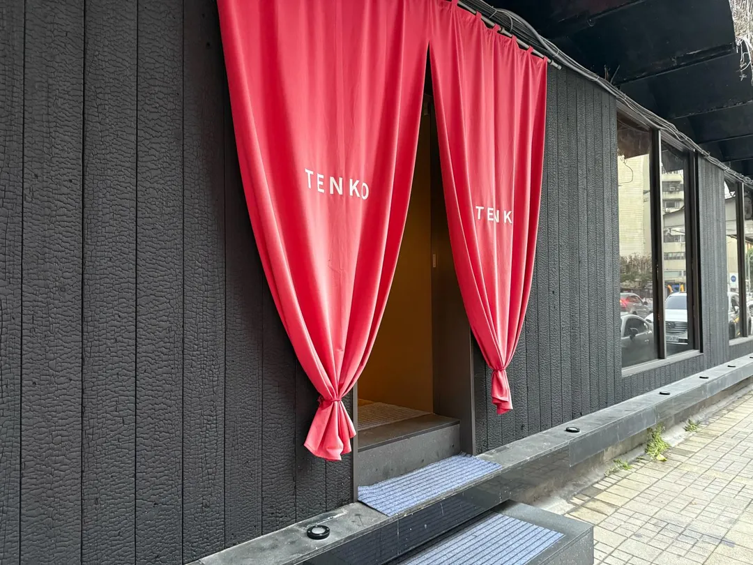 烏黑木板與桃紅暖簾。(圖/黃宏輝提供)