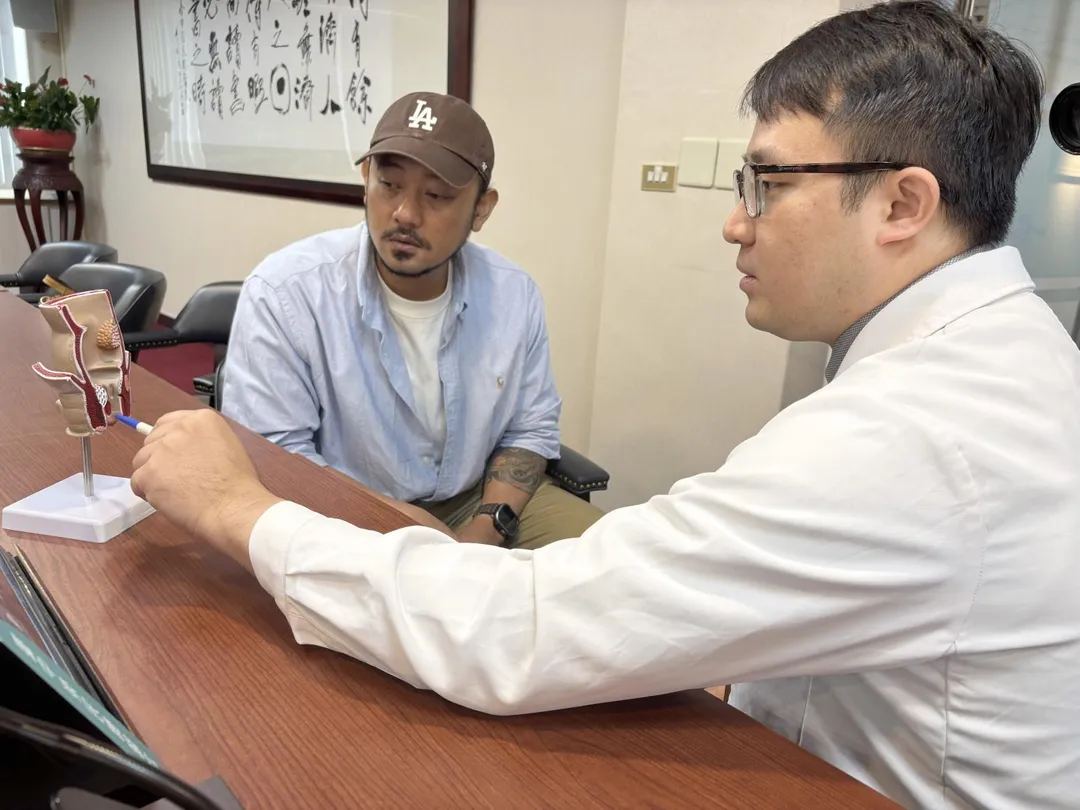 臺中榮總大腸直腸外科醫師洪浚嚴(右)向王先生(左)說明TNT治療中低位直腸癌方式。(圖/臺中榮總)