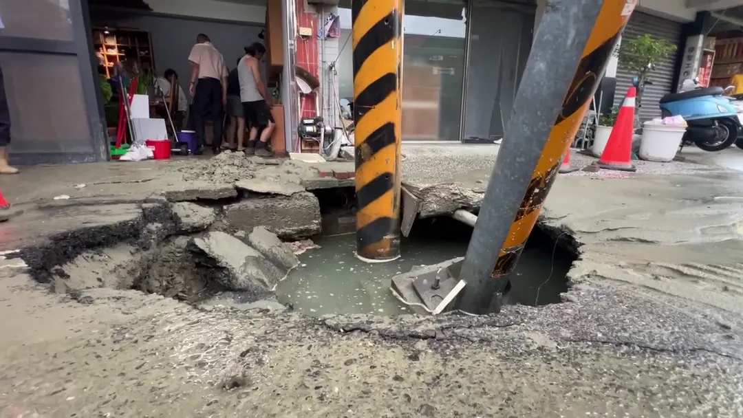 台南市仁德區中正路二段今晨發生路面塌陷，路標指示桿慘遭坑洞吞噬。（圖／中天新聞）