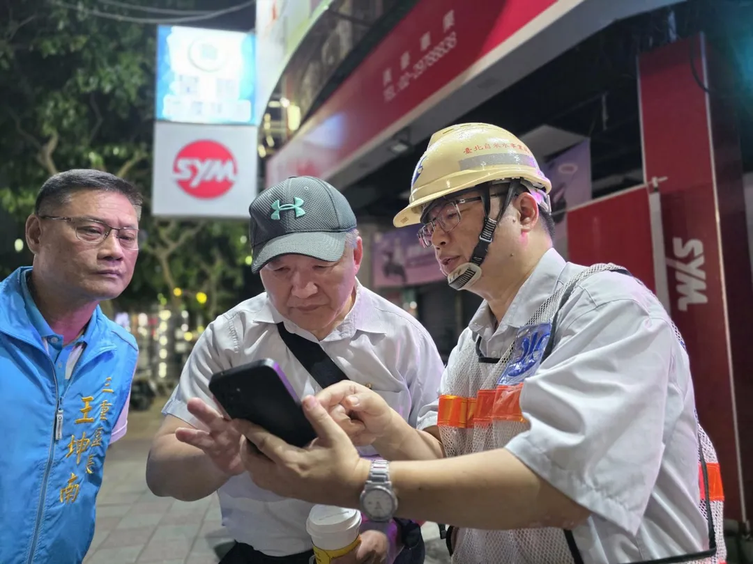 三重區成功路與集成路口發生自來水管線破損,工務局長馮兆麟(中)趕赴現場,並與北水處人員討論了解狀況。(圖/新北市工務局提供)