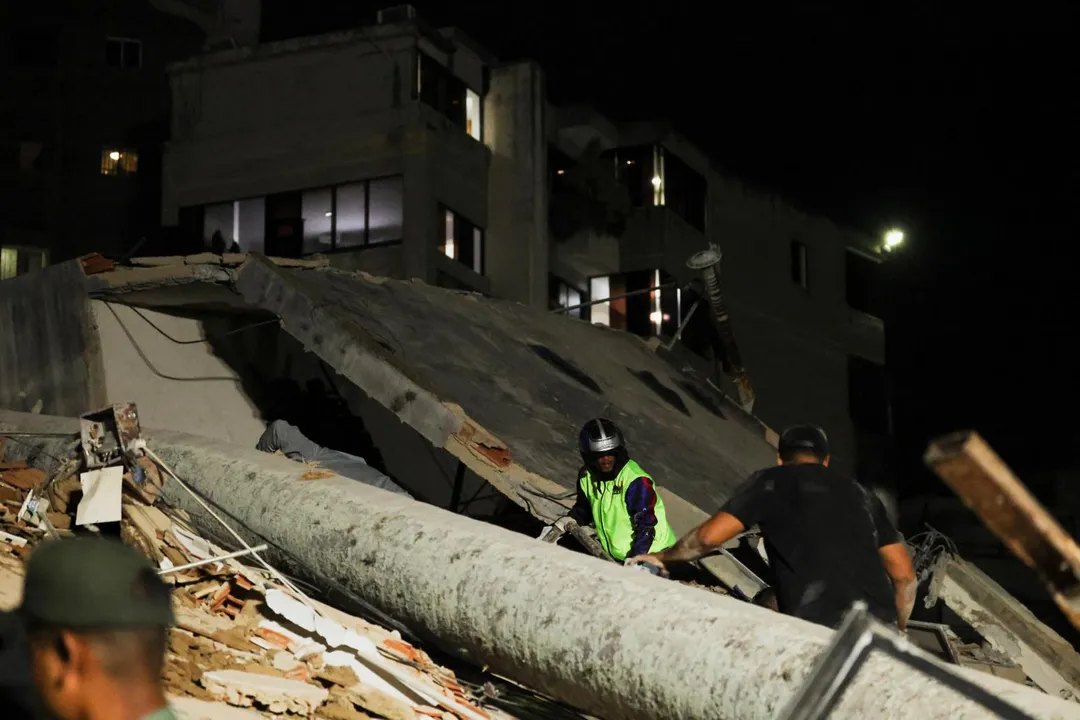 24日強震後，委內瑞拉首都卡拉卡斯建築物當場倒塌。（圖／路透社）