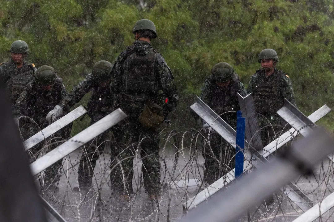 第54工兵群在雨中架設鋼刺蝟、蛇腹型鐵絲網。(圖/軍聞社)