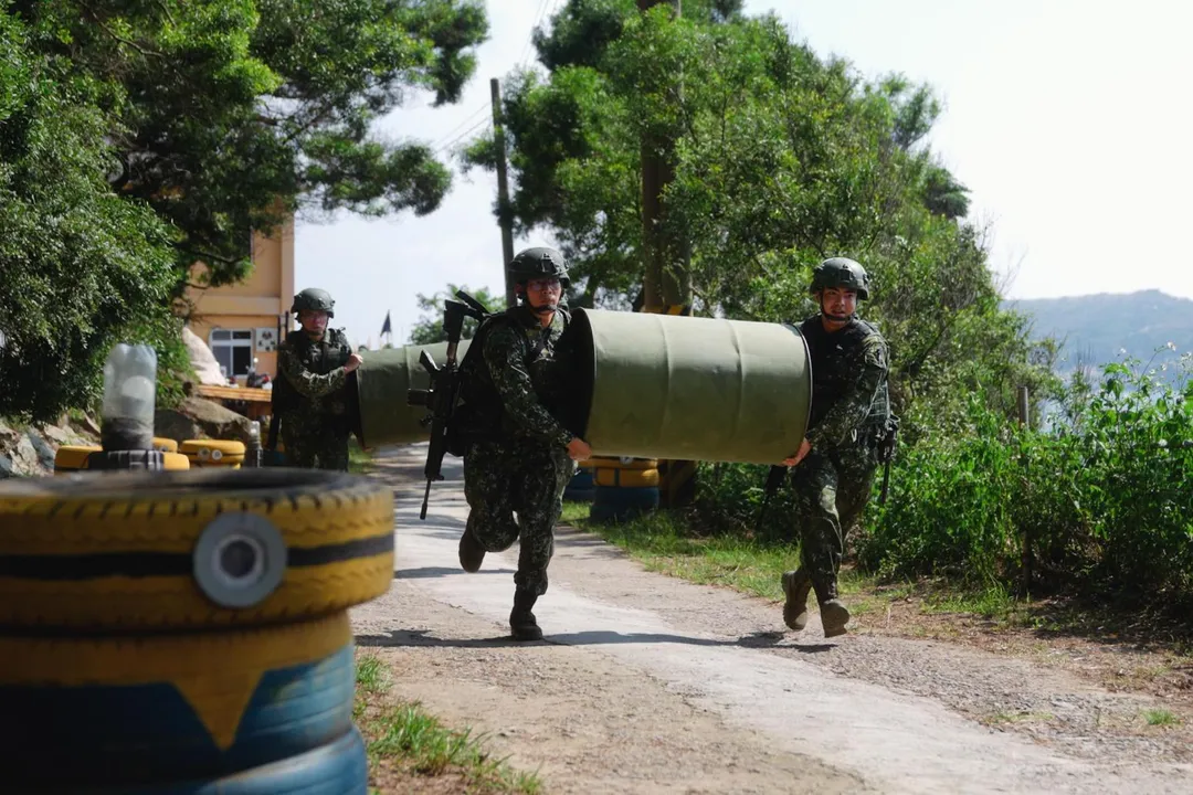 北高守備大隊官兵搬運汽油桶到定位演練阻絕架設。(圖/軍聞社)