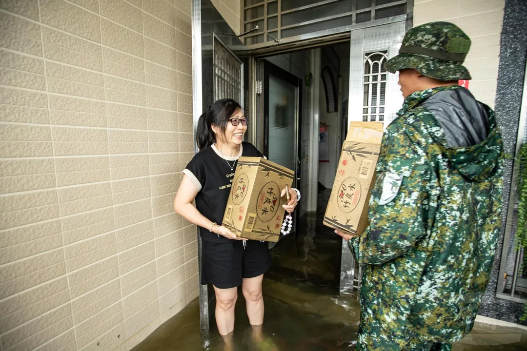 空訓中心特戰官兵在杉林地區涉水將民生必需品送到受困民眾家中。(圖/軍聞社)