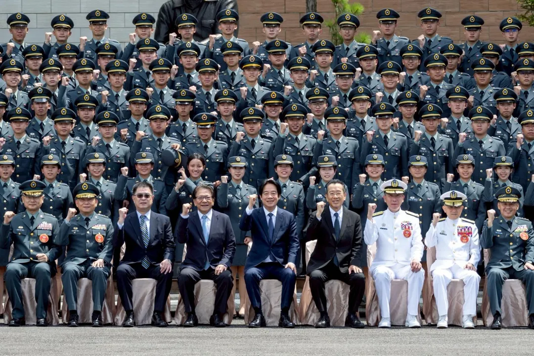 賴清德與軍校畢業生合影,注意有新科女軍官的帽子被後方同學不小心碰掉。(圖/總統府)