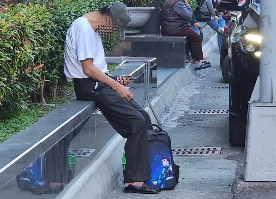 周姓男子在ATM旁閒晃呆坐、頻盯手機，行跡十分可疑。（圖／警方提供）