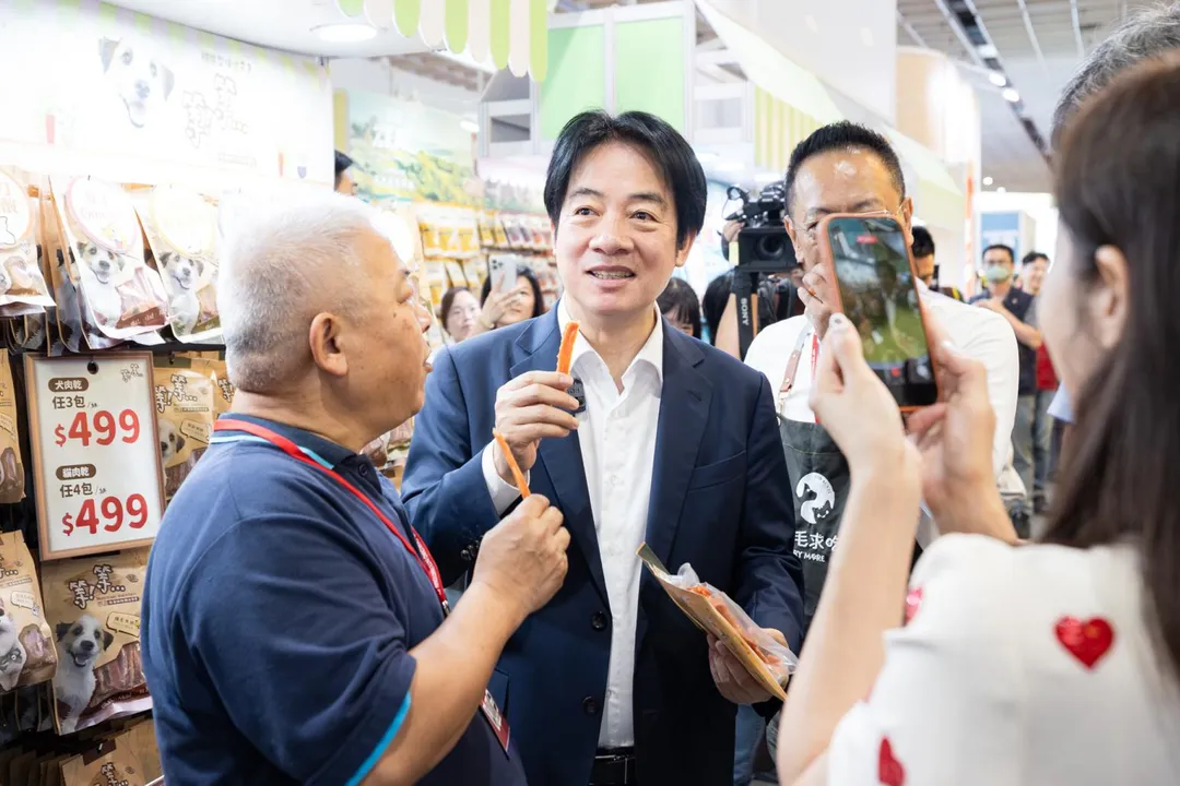 寵物用品展廠商邀請賴清德試吃寵物肉乾。(圖/總統府)