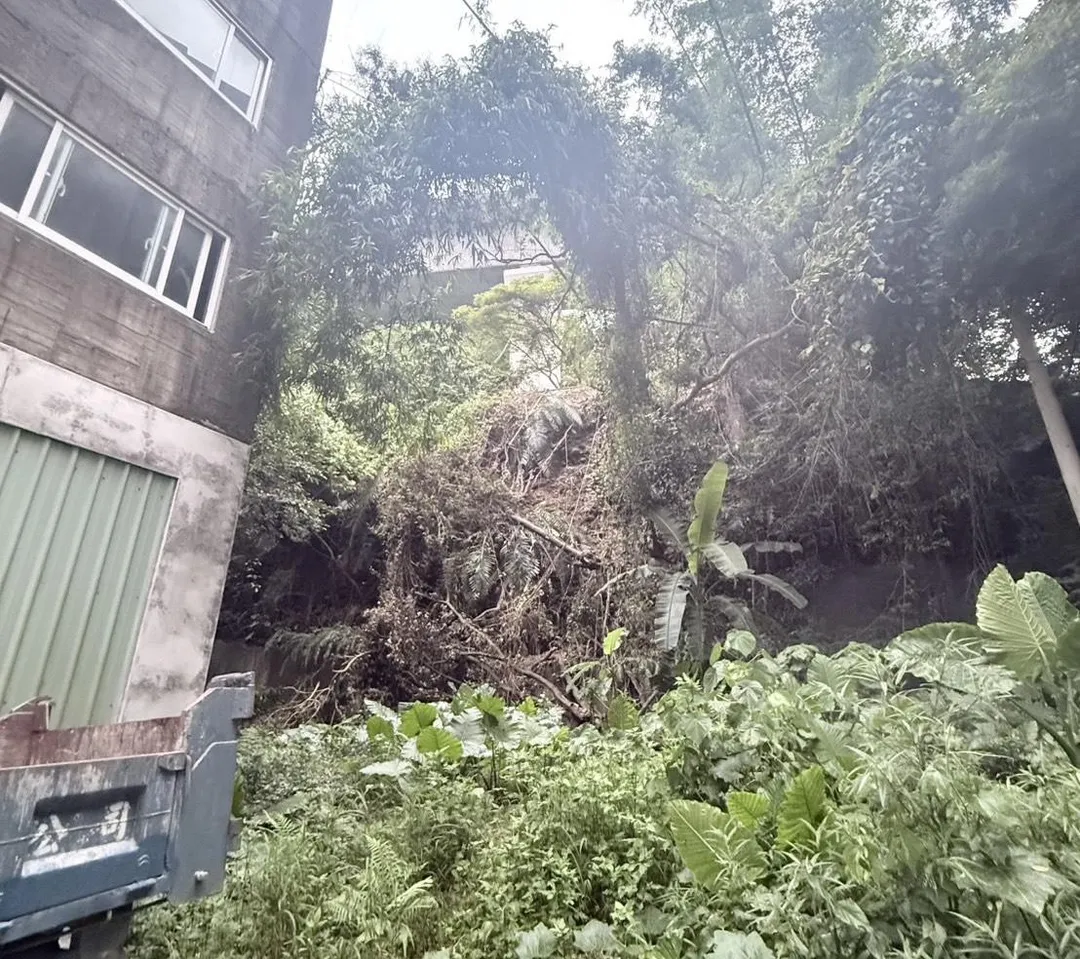 新北市新莊區新北大道七段一處社區後方，今（6）日下午因午後暴雨導致荒地土坡崩落。（圖／翻攝畫面）