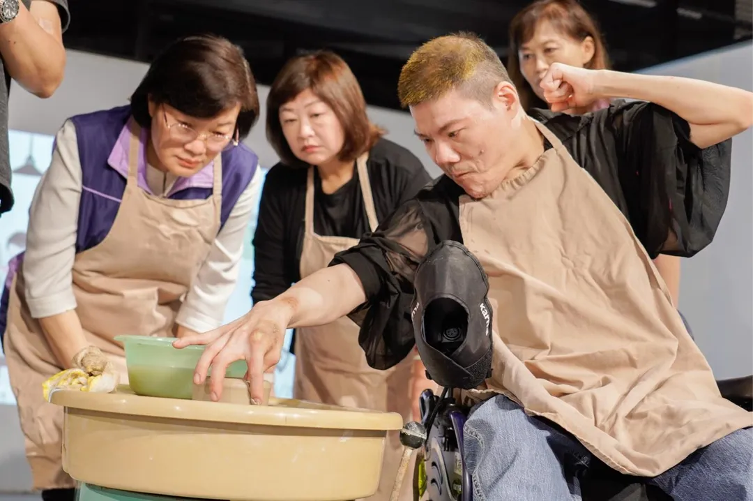 重度肢體障礙的阿琮以右手拇指與食指精準捏製容器。（圖／新北市政府社會局提供）