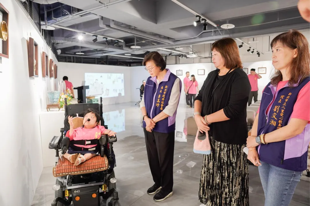 院生小雪(左1)向來賓分享展覽中每個作品的製作過程及故事。左2為新北社會局長李美珍、（圖／新北市政府社會局提供）