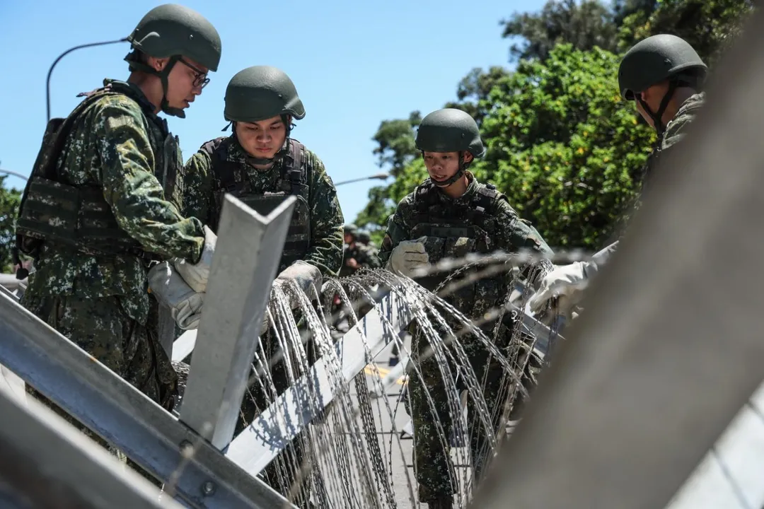 第52工兵群常備幹部(中)帶領後備軍人(圖左2名)在鋼刺蝟上架設鐵絲網。(圖/第10軍團提供)