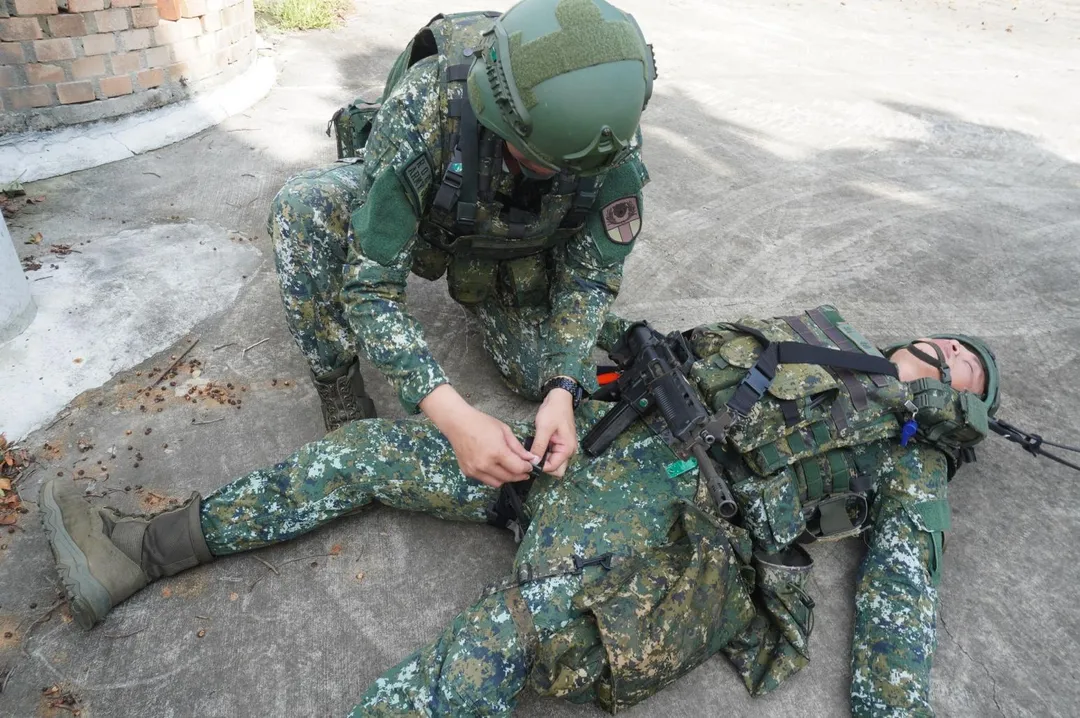 第302旅官兵演練戰傷救護，在傷兵腿部繫上止血帶。(圖/第10軍團提供)
