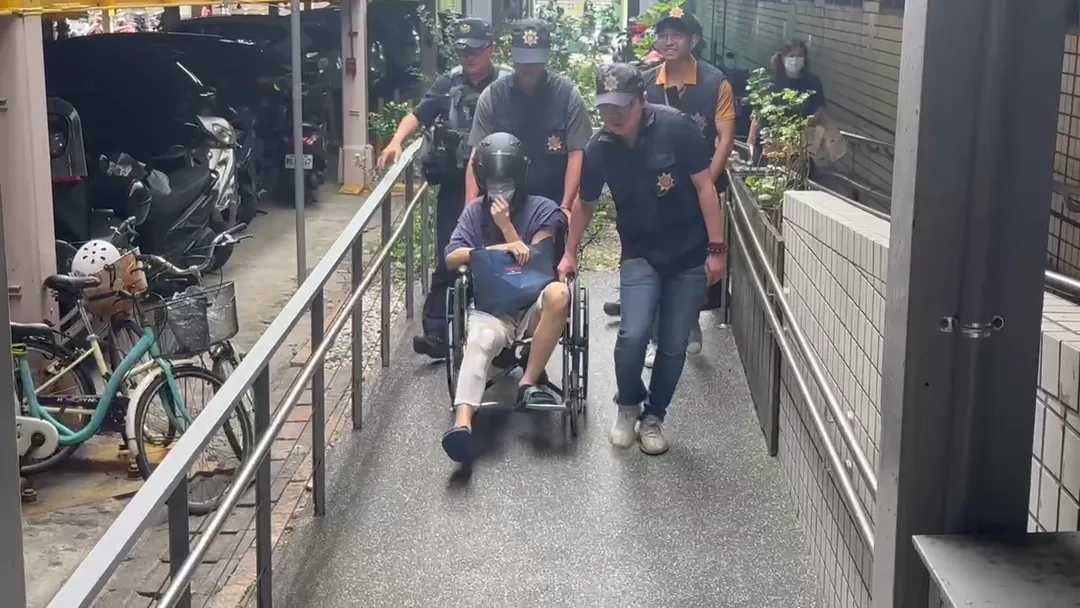 林男24日上午出院後,在10名警力戒護下坐輪椅被帶上車移送新竹地檢署。(圖/中天新聞)
