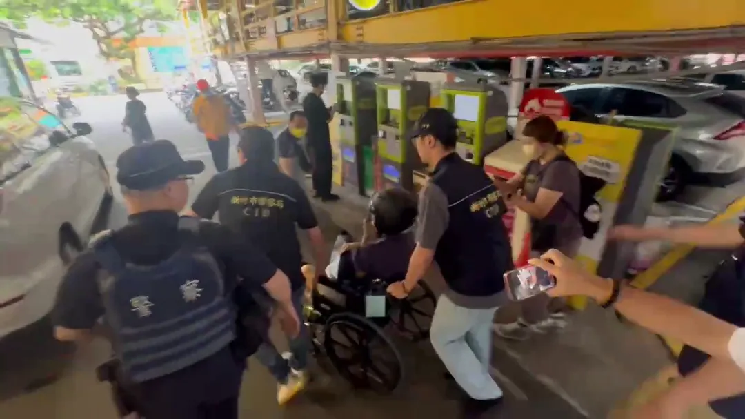 林男24日上午出院後,在10名警力戒護下坐輪椅被帶上車移送新竹地檢署。(圖/中天新聞)
