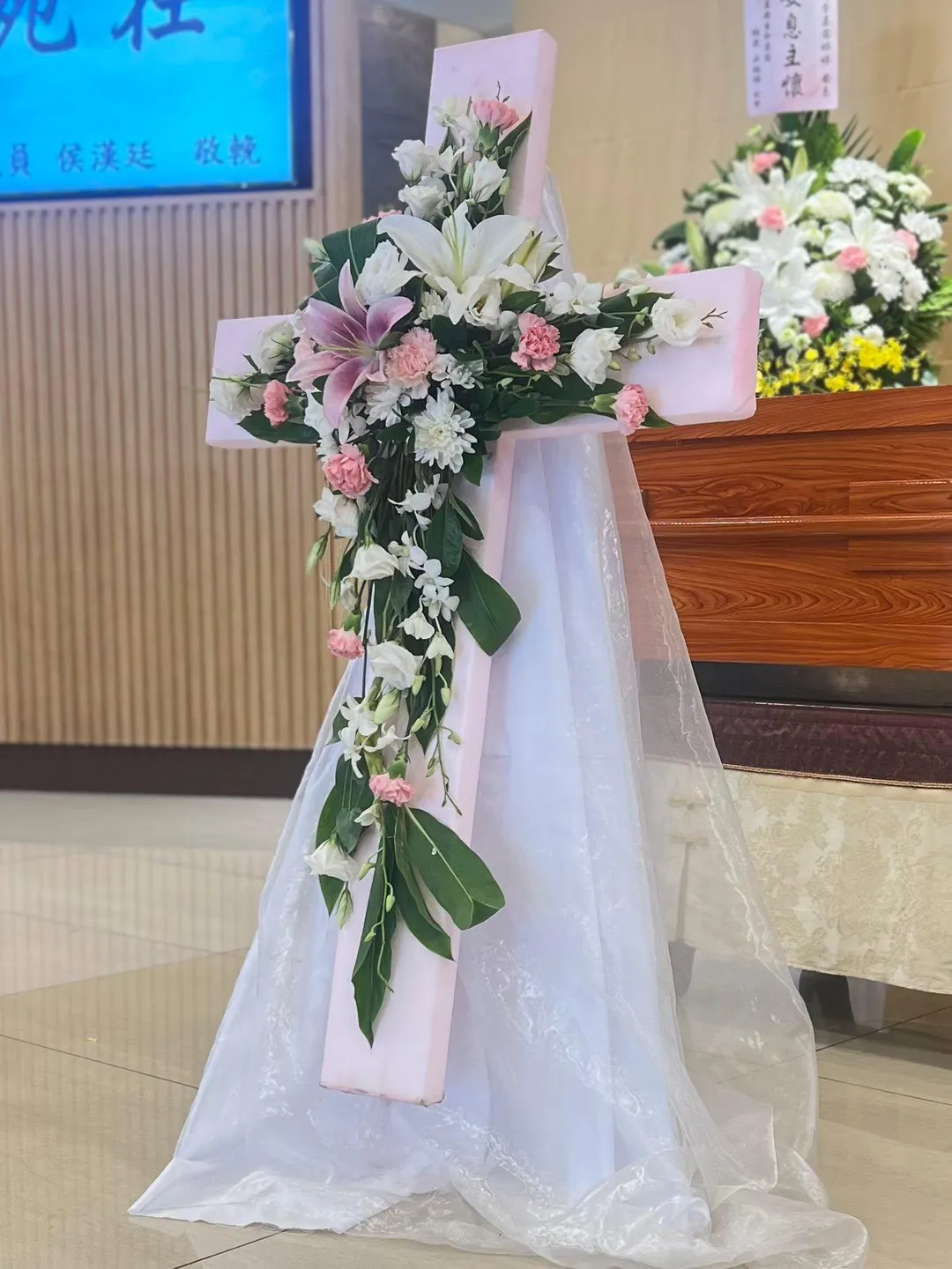 李嘉茜追思會場十字架，靈柩前擺滿白百合。（圖／翻攝吳恩文臉書）