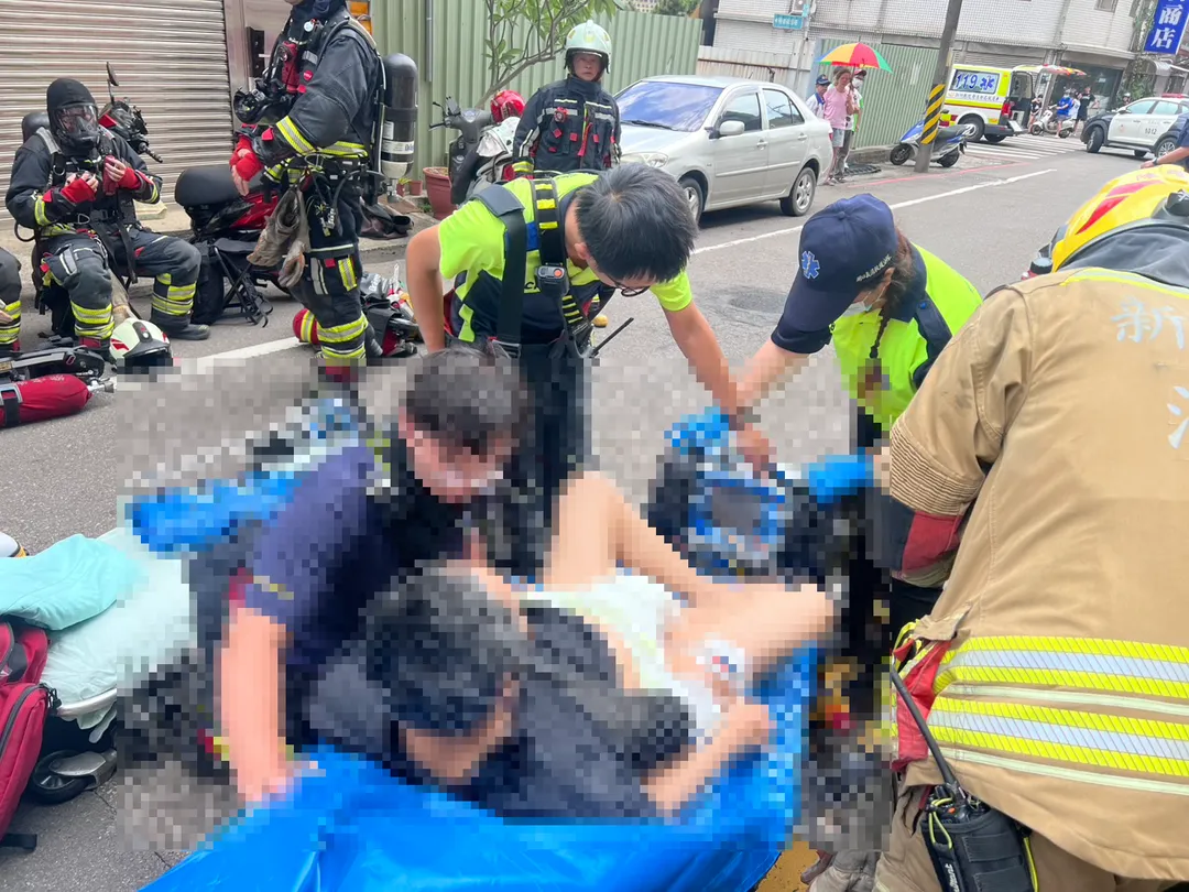 新竹縣湖口鄉明德街一處四層半住宅31日中午發生火警，現場冒出濃煙且有人受困。（圖／警消提供）