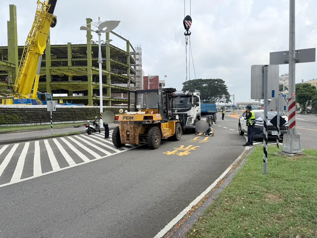 警方獲報趕抵現場後，連忙協調在旁施工的大型吊車與堆高機前來支援，將車體抬高後，成功將受困的連姓婦人救出送醫。（圖／警方提供）