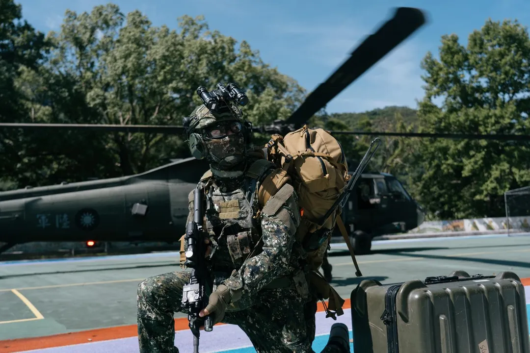 搭乘UH-60M機降的陸軍特戰官兵在降落區警戒,M4步槍上裝有瞄準鏡及雷指器、槍燈。(圖/國防部)