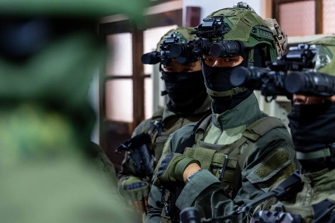 穿著橄欖綠色戰鬥衫的海龍蛙兵進行任務提示,頭戴的高耳型防彈盔都加裝雙筒夜視鏡。(圖/國防部)