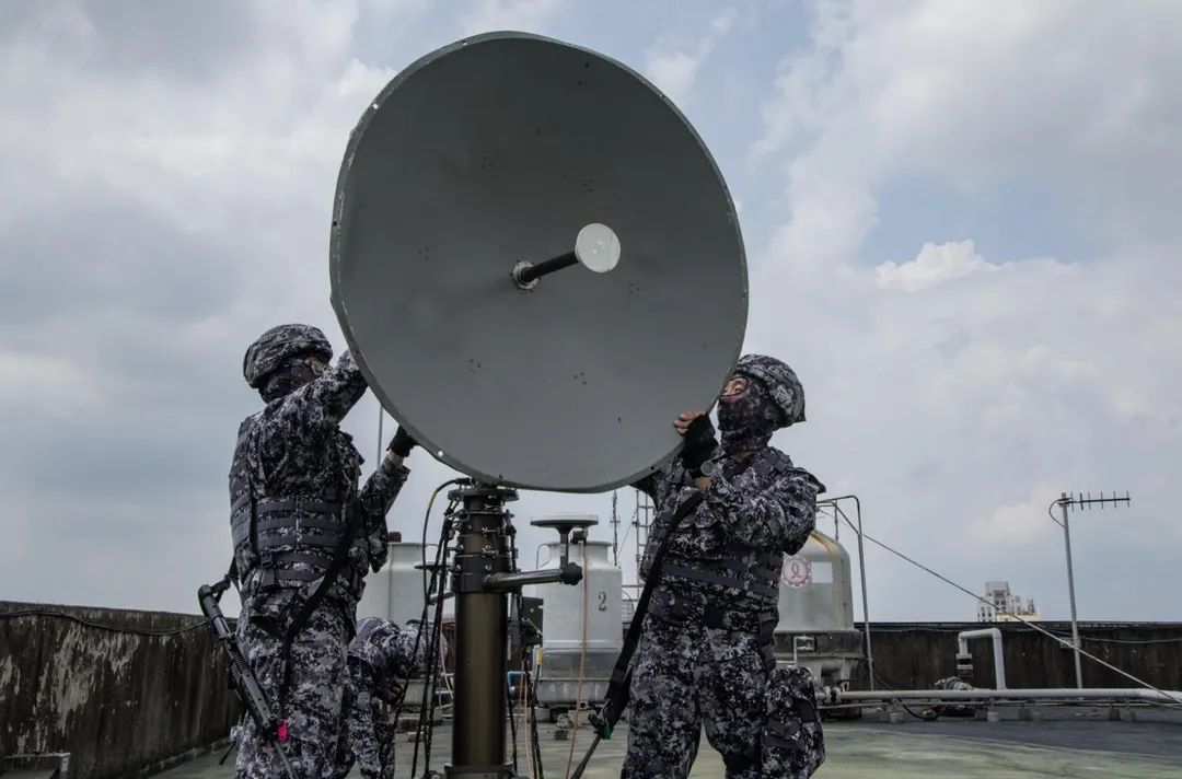 資通電軍官兵在樓頂架設微波系統的碟型天線。(圖/國防部)