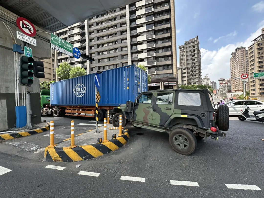 新北市淡水區淡金路一段、北新路口今（14）日上午發生一起貨櫃車與軍用吉普車擦撞事故。（圖／翻攝畫面）