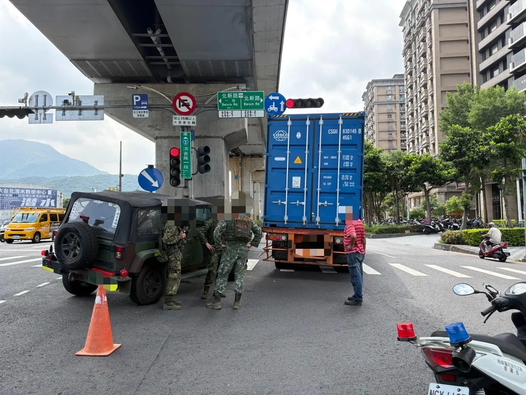猛烈碰撞後，軍用吉普車遭貨櫃車卡住並拖行，最後直接被帶上分隔安全島。（圖／翻攝畫面）