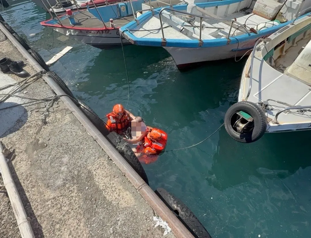 海巡人員牢牢緊抓落水老船長。(圖/第二岸巡隊提供)