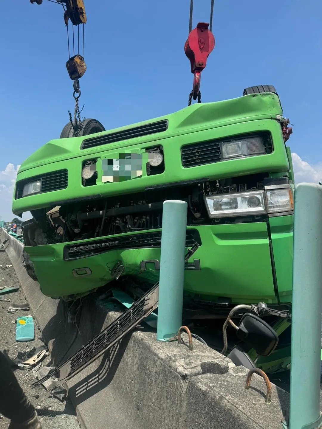 國道1號新營段化學槽車翻覆,車輛四輪朝天,躺在南下車道,靠在中央護欄,車頭幾乎全毀。(圖/中天新聞)