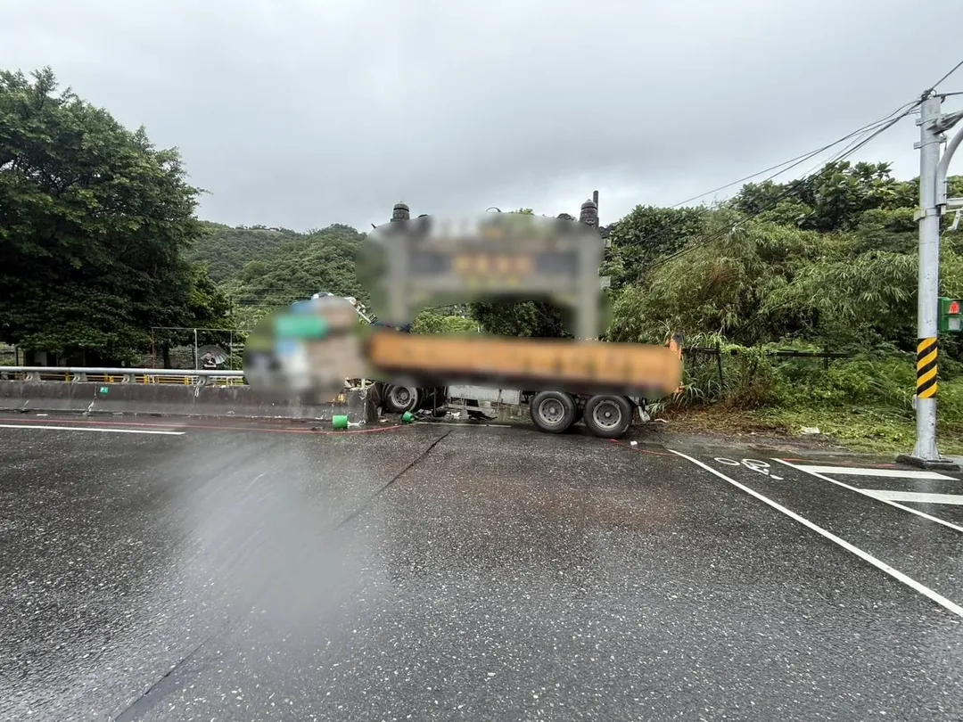 事故現場砂石車撞倒路邊大型招牌與周邊設施，龐大車斗橫向卡在路旁等待排除。（圖／警方提供）