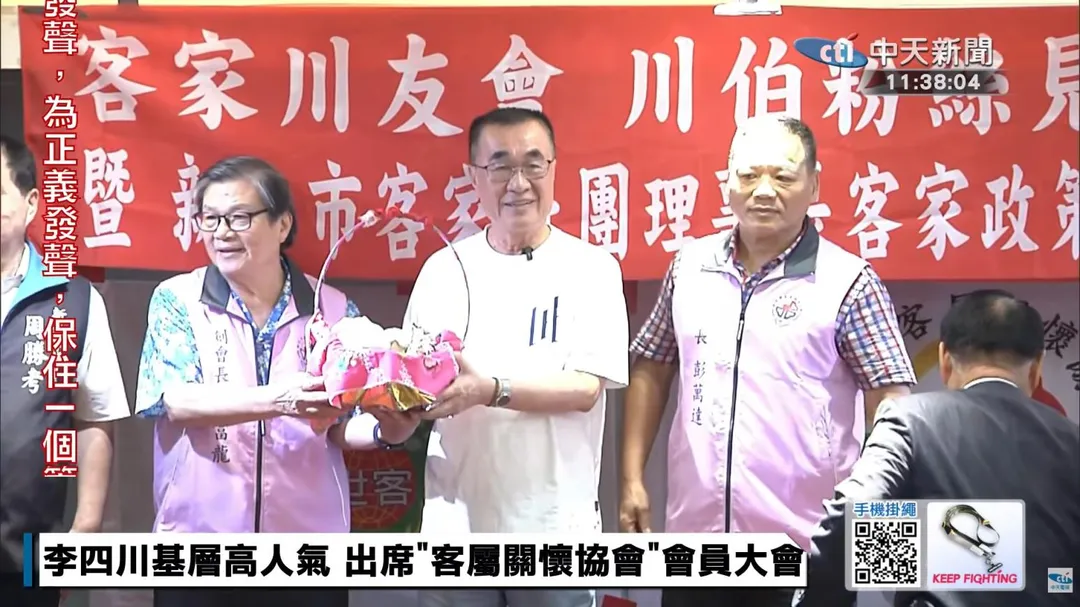 湯富龍與彭萬達代表客家鄉親致贈象徵「包中(粽)」的好彩頭給李四川。(圖/中天新聞)
