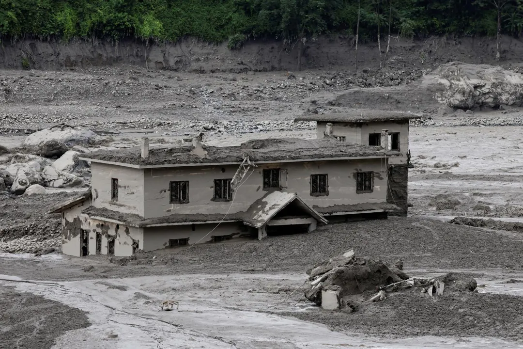 一棟建築物遭滾滾土石流沖毀。（圖／路透社）